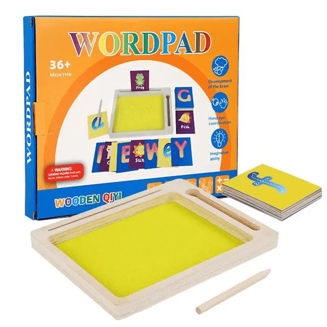 Wooden sand writing tray with bright yellow kinetic sand surface, wooden stylus and a set of illustrated alphabet and picture flashcards, shown alongside its colourful orange