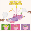 Children's toy tennis set with rackets and ball on a pink court, featuring text 'Hit the Cap, Flip & Score!'.