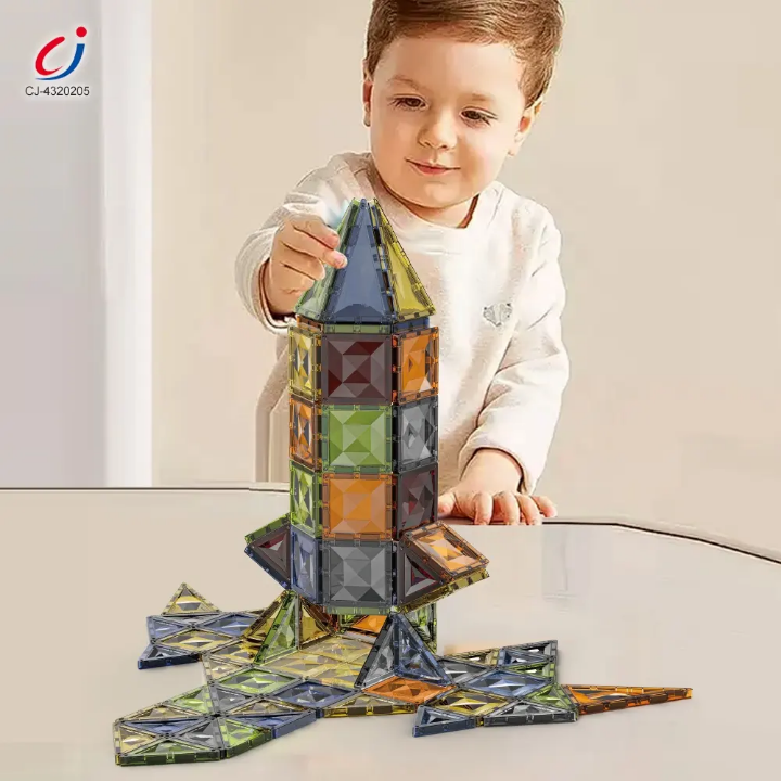 Child playing with a colorful magnetic building set on a light surface.