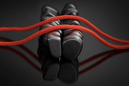 Red jump rope with black magnets on a reflective dark surface