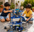 Two children playing with a toy police station set outdoors.